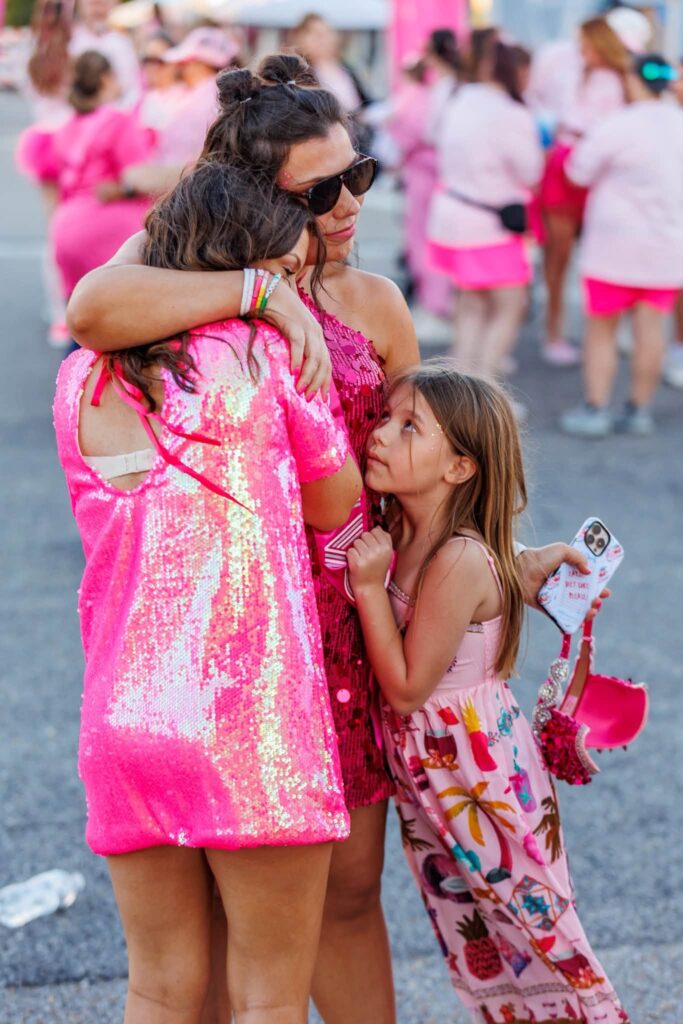 A mom in pink sequins hugging her daughter